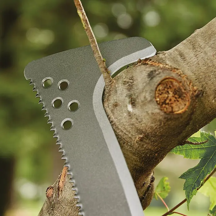 Fiskars Solid Machete mit Sägekante - Länge: 45 cm - Nahaufnahme einer Metallsäge, die einen Ast durchschneidet. Das Werkzeug ist robust und für Outdoor-Aktivitäten konzipiert.