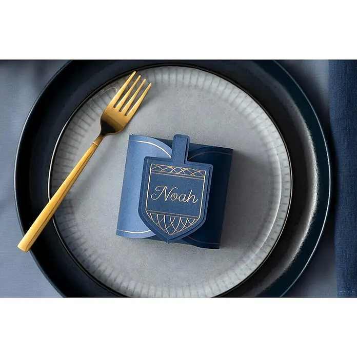 Cricut Maker Schneideplotter Maker 3 - Blau, Bluetooth, Schnittbreite: 29,7 cm, Schnittlänge: 3,6 m - Festlicher Tisch mit goldenem Besteck und blauem Namensschild mit dem Namen "Noah", perfekt für besondere Anlässe.