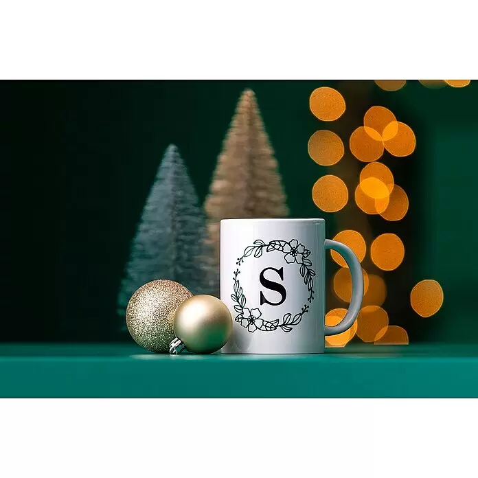 Cricut Joy Schneideplotter Smarte Schneide- und Zeichenmaschine - Türkis/Weiß, Bluetooth, Schnittbreite: 10,4 cm, Schnittlänge: 1,2 m - Weiße Tasse mit dunkelgrünem "S"-Monogramm in einem Blumenkranz, umgeben von goldenen Weihnachtsbaumkugeln und festlichen Lichtern.