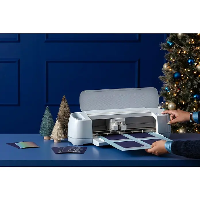 Cricut Maker Schneideplotter Maker 3 - Blau, Bluetooth, Schnittbreite: 29,7 cm, Schnittlänge: 3,6 m - Nahaufnahme einer Cricut Maker 3 Schneidemaschine in einer festlichen Umgebung mit weihnachtlichen Dekorationen.
