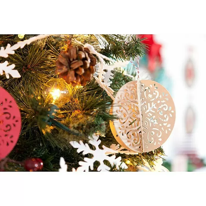 Cricut Joy Schneideplotter Smarte Schneide- und Zeichenmaschine - Türkis/Weiß, Bluetooth, Schnittbreite: 10,4 cm, Schnittlänge: 1,2 m - Aufwendig geschnittenes hellbraunes Papierkugel-Ornament an einem festlichen Weihnachtsbaum, geschmückt mit weißen Schneeflocken und warmen Lichtern.