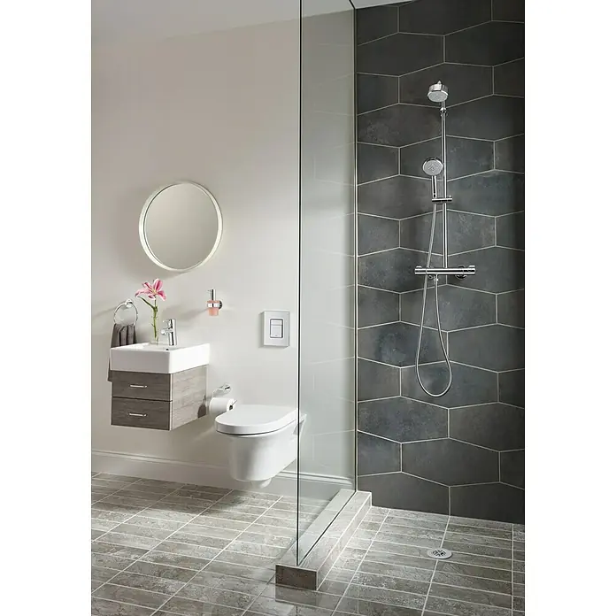 Grohe Essentials Seifenspender - Mit Halterung, Chrom, Glänzend - Das moderne Badezimmer verfügt über eine stilvolle Toilette, Waschbecken und Dusche mit grauen Fliesen. Die Spiegel und Armaturen ergänzen das Gesamtbild.
