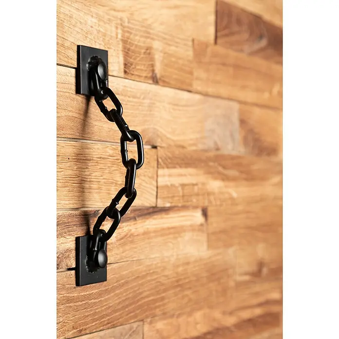 Kornik Griff Kette - Schwarz, 183 x 40 mm - Detailaufnahme einer rustikalen Wanddekoration mit einer schwarzen Kette, die an Holzpaneelen befestigt ist und einen industriellen Akzent setzt.