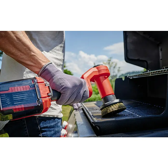Einhell Power X-Change 18V Ersatzbürste ULTRA 95/25 - Passend für: Einhell Power X-Change 18V Akku-Reinigungsbürste Picobella 18/90 - Mann reinigt einen Grill mit einer elektrischen Grillbürste, ausgestattet mit einem rotierenden Bürstenkopf und einem transparenten Batteriepack.