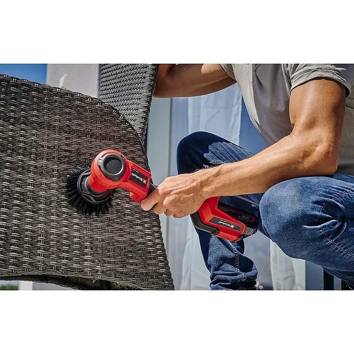 Einhell Power X-Change 18V Ersatzbürste SOFT 120/50 - Passend für: Einhell Power X-Change 18V Akku-Reinigungsbürste Picobella 18/90 - Ein Mann reinigt einen Rattansessel mit einer roten Einhell Akku-Bürste, um das Möbelstück sauber und gepflegt zu halten.\n