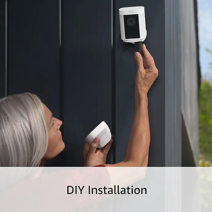 Ring Überwachungskamera Spotlight Cam Pro Wired - Weiß, Auflösung: 1.080 Pixel (Full HD), Festverdrahtet - Nahaufnahme einer Frau, die eine Ring Sicherheitskamera an einer Hauswand montiert. DIY Installation der Ring-Überwachungskamera.