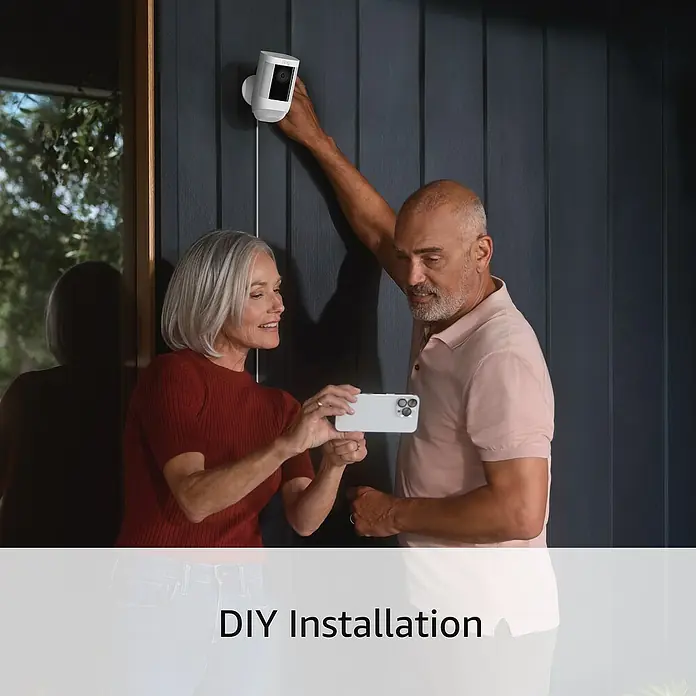 Ring Überwachungskamera Spotlight Cam Pro Wired - Weiß, Auflösung: 1.080 Pixel (Full HD), Festverdrahtet - Überwachungskamera-Installation: Ein Paar installiert eine Ring-Überwachungskamera mit Smartphone-Hilfe für mehr Sicherheit im Haus.