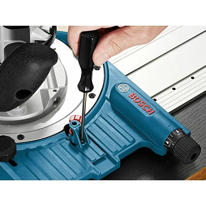 Bosch Professional Adapter Lochrastersystemadapter FSN RA 32 - Passend für: Bosch Professional FSN OFA Fräsdapter - Detailaufnahme einer Bosch Kapp- und Gehrungssäge beim Justieren mit einem Schraubenzieher.