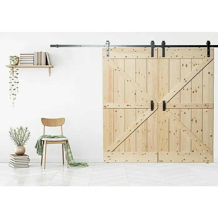 Kornik Holzschiebetür Loft - 96 x 206 cm, Kiefer - Eine rustikale Schiebetür aus hellem Holz mit schwarzen Beschlägen vor einer weißen Wand.