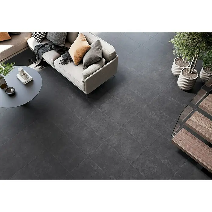 Feinsteinzeugfliese Classico Nero - 44 x 66 cm, Schwarz, Matt - Ein grauer Bodenbelag aus Fliesen mit subtiler Textur im Wohnzimmer, der einen modernen und eleganten Look erzeugt.