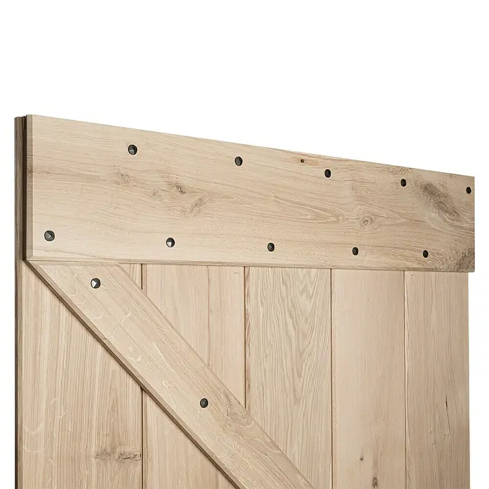 Kornik Holzschiebetür Loft - 96 x 206 cm, Eiche - Nahaufnahme einer hellen Holztür im Scheunenstil mit einem markanten Z-förmigen Design und dekorativen, dunklen Akzentnieten.