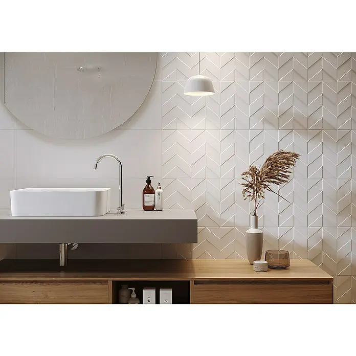Wandfliese White Satin - 29 x 89 cm, Weiß, Matt - Elegantes Badezimmer-Interieur mit einem modernen Waschbecken, einem runden Spiegel und einer auffälligen Wandfliese mit Chevron-Muster.