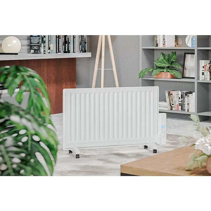Voltomat HEATING Ölradiator - 800 W, Raumgröße bis ca. 8 m², Weiß - Ein weißer Heizkörper mit Rippen und Rollen steht in einem stilvollen Wohnzimmer. Er sorgt für Wärme und Komfort in Ihrem Zuhause.