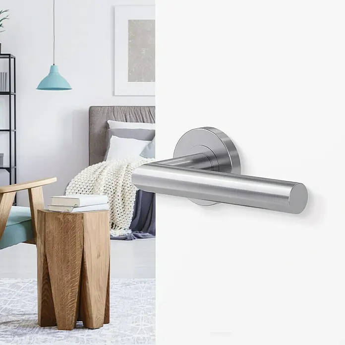 Diamond Doors Modern Zimmertürgarnitur L-Form Premium - Stärke Tür: 38 mm - 45 mm, Edelstahl, L-Form, Edelstahl matt - Nahaufnahme eines modernen Türgriffs aus Edelstahl vor einem stilvollen Schlafzimmerhintergrund.