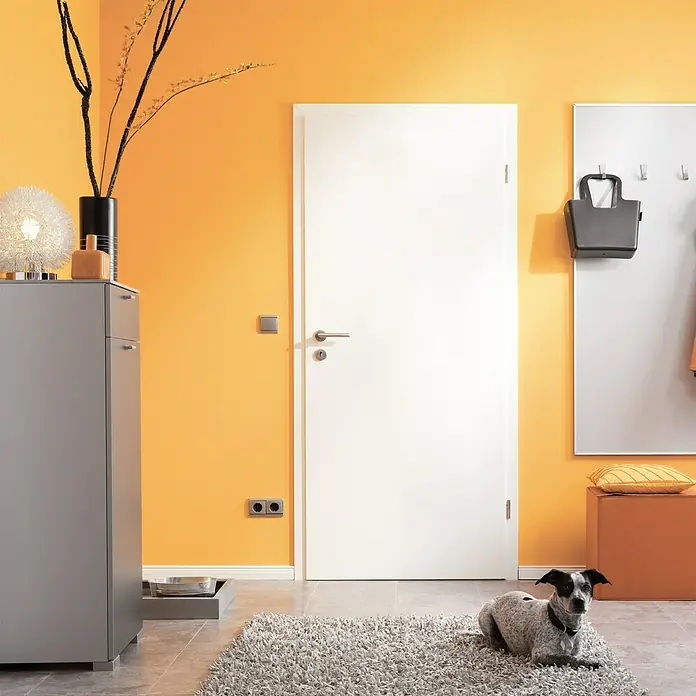 Kilsgaard Wohnungseingangstür Typ 52 SK1 KK3 - Klimaklasse nach RAL: III, 860 x 1.985 mm, DIN Anschlag: Rechts, Weiß lackiert, ähnlich RAL 9010 - Eine moderne weiße Innentür mit einer silbernen Türklinke, die sich in einem Flur mit orangefarbenen Wänden befindet.