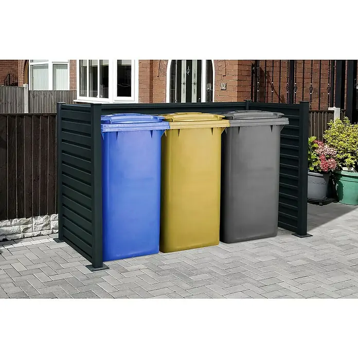 Floraworld Mülltonnenverkleidung - Stahl, Anthrazit, Geeignet für Anzahl Mülltonnen: 3 Stk. - Mülltonnenbox mit drei farbigen Mülltonnen (blau, gelb, grau) auf einem gepflasterten Untergrund, umgeben von einem Sichtschutz.
