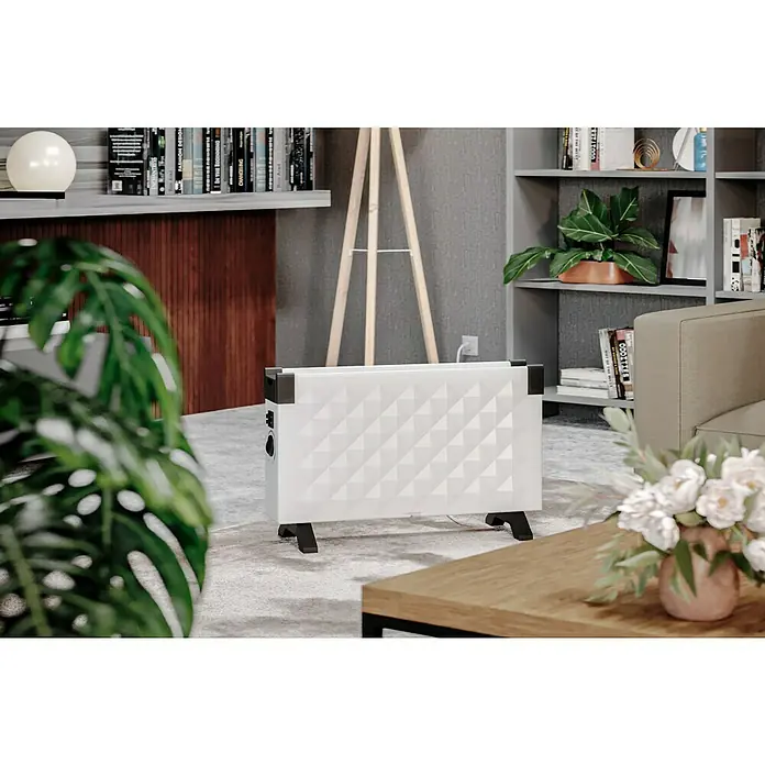 Voltomat HEATING Convector Rombo mini - 2.000 W, Habitaciones de hasta 25 m², Blanco/Negro - Primer plano de un calefactor blanco y elegante con un patrón geométrico en una habitación decorada modernamente.