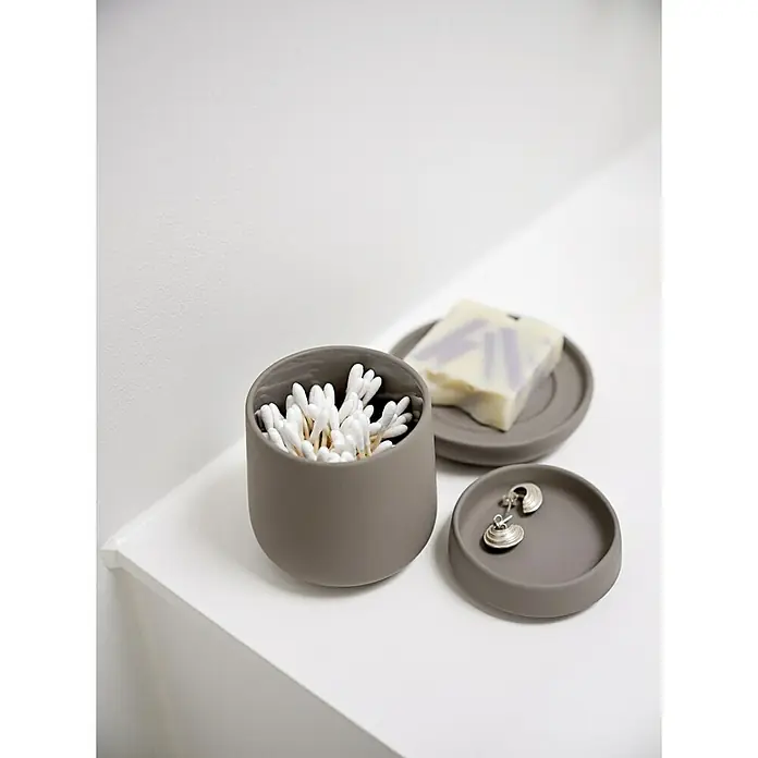 Zone Denmark Nova One Kosmetikdose - Steingut, Gull Grey - Badezimmer-Accessoires aus Keramik: Ein Behälter mit Wattestäbchen, eine Seifenschale mit Seife und eine Schmuckschale mit Ohrringen.