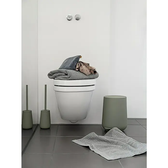 Zone Denmark Nova One Kosmetikeimer - 3 l, Kunststoff, Matcha Green - Detailansicht eines Badezimmers mit hängendem WC, WC-Garnituren und einem Handtuch. Das Bad ist modern und minimalistisch gestaltet.