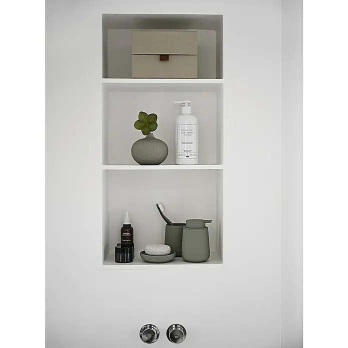 Zone Denmark Nova One Seifenschale - Porzellan, Matcha Green - Badezimmerregal mit Seifenspender, Lotion, Zahnbürste und dekorativer Vase. Die Farbtöne sind neutral und schaffen eine ruhige Atmosphäre.