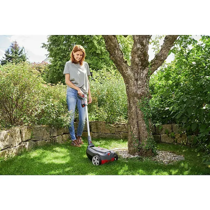 AL-KO Bosch Home & Garden Compatible Akku-Rasenmäher 22.4 LI Comfort - 18 V, 1 Akku, 2,5 Ah - Frau benutzt einen Rasenkantenschneider im Garten.