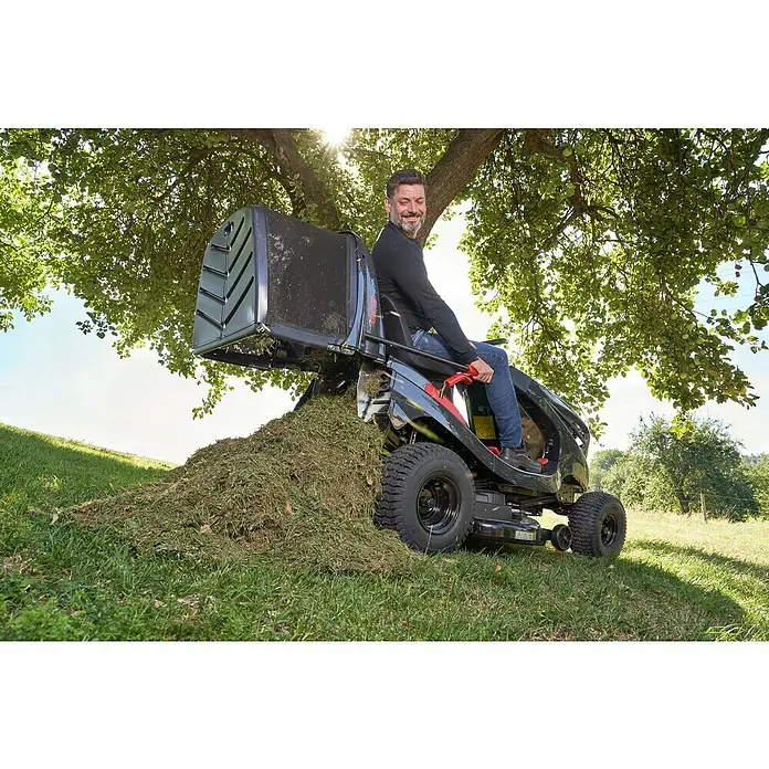 AL-KO Comfort Rasentraktor 18-103.4 HD-A V2 - 568 cm³, Schnittbreite: 103 cm - Mann auf einem Rasentraktor mit Grasfangkorb, der Grasschnitt ablädt. Der Rasentraktor ist das Hauptprodukt.