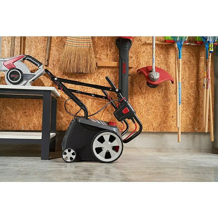 AL-KO Easy Elektro-Vertikutierer-Lüfter 38.4 E Combi Care - 1.400 W, Arbeitsbreite: 38 cm - Abgebildet ist ein Rasenlüfter der Marke AL-KO, der für die Gartenpflege verwendet wird. Das Gerät steht auf einem Betonboden in einer Garage.