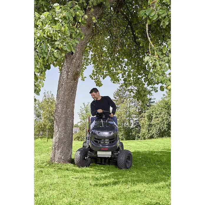 AL-KO Comfort Rasentraktor 18-111.4 HDS-A V2 - 568 cm³, Schnittbreite: 110 cm - Ein Mann fährt mit einem AL-KO Aufsitzmäher unter einem Baum im Garten.