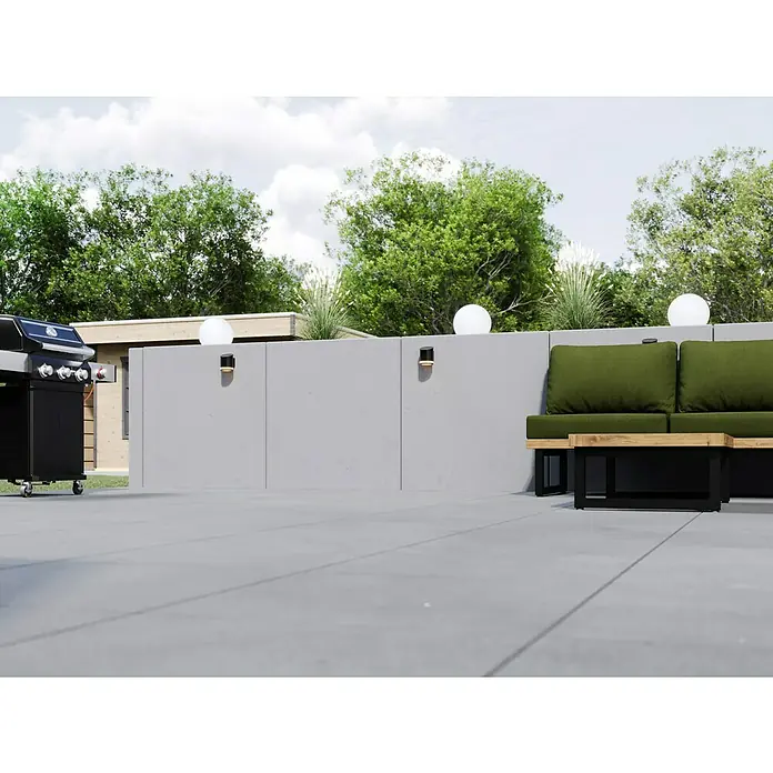 Diephaus L-Stein - 105 cm, 100 cm, Stärke: 12 cm, Grau - Ein Außengrill und Gartenmöbel stehen auf einer Terrasse, umgeben von üppigem Grün. Ideal für entspannte Stunden im Freien.