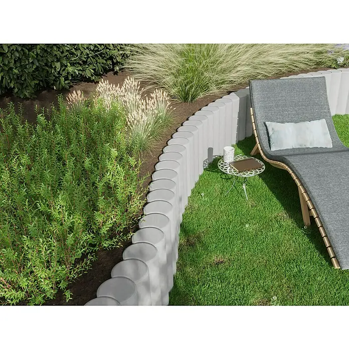 Diephaus Rundpalisade - Ø x H: 20 x 80 cm, Grau, Beton - Gartengestaltung mit Rasen, Pflanzen und einer grauen Liege. Der graue Rasenkantenstein dient als stilvolle Begrenzung und Hingucker.