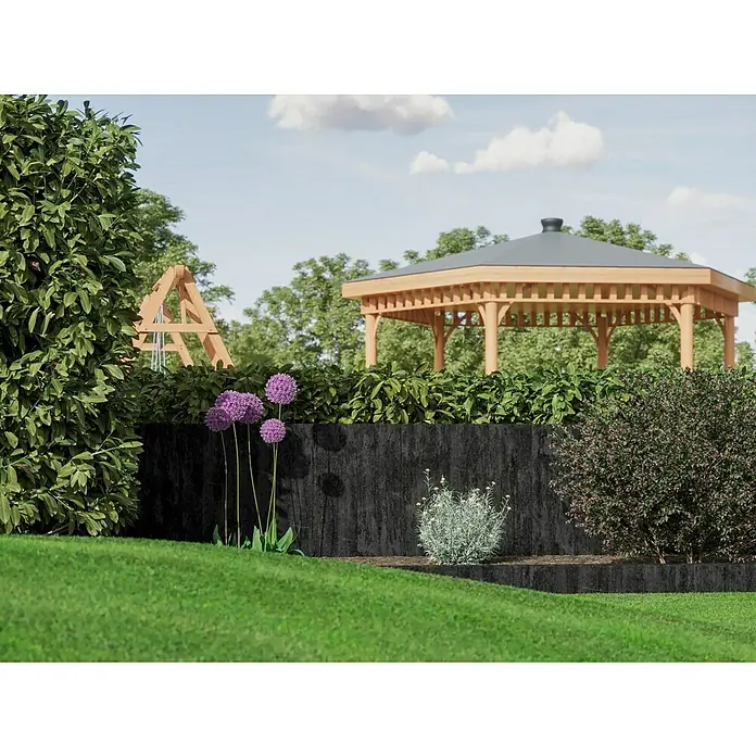 Diephaus Palisade Niles - 90 x 20 x 8 cm, Basalt, Beton - Eine Gartenlandschaft mit blühenden Allium-Pflanzen vor einer dunklen Stützmauer, mit einer hölzernen Gartenlaube im Hintergrund.