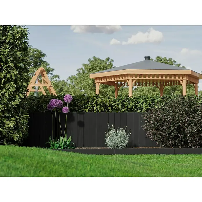 Diephaus Palisade / Mauerstein Laredo Meso - 80 x 10 x 10 cm, Basalt, Beton - Gartenszene mit einem erhöhten Beet, eingefasst von einer modernen, schwarzen Holzwand, die die grüne Vegetation und die Blumen schön hervorhebt.