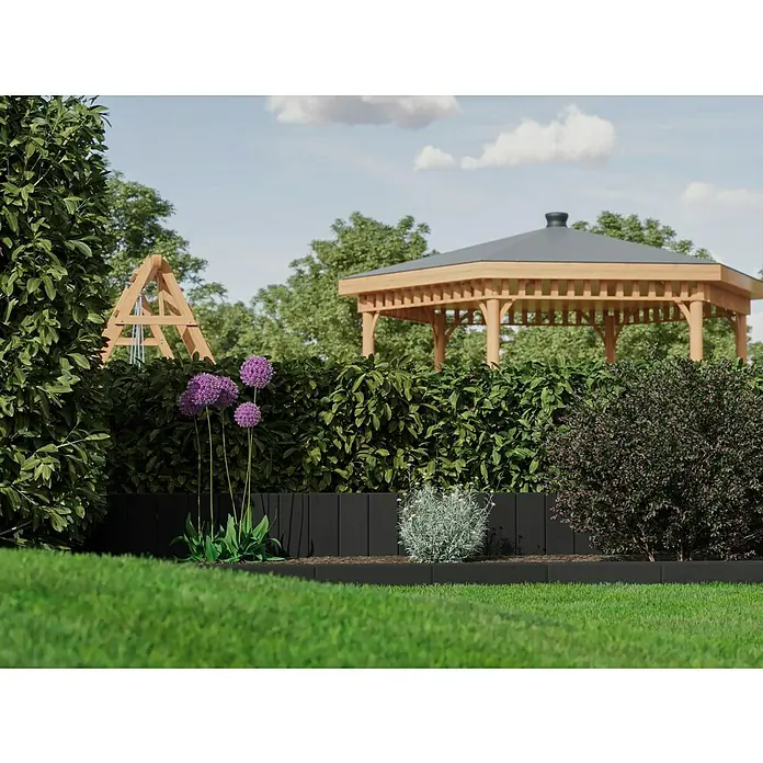 Diephaus Palisade / Mauerstein Laredo Meso - 40 x 12,5 x 12,5 cm, Basalt, Beton - Nahaufnahme eines Gartens mit Blumen, Sträuchern und einem schwarzen Beetrand, der die grüne Rasenfläche abgrenzt. Im Hintergrund ein Gartenhaus.