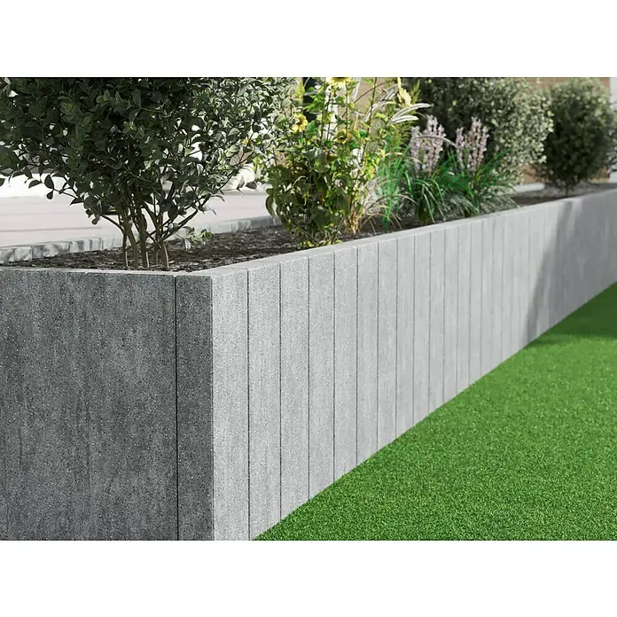 Diephaus Palisade Niles - 90 x 20 x 8 cm, Granit, Beton - Nahaufnahme eines erhöhten Gartenbeets mit grauen Betonsteinen und üppigen Pflanzen.