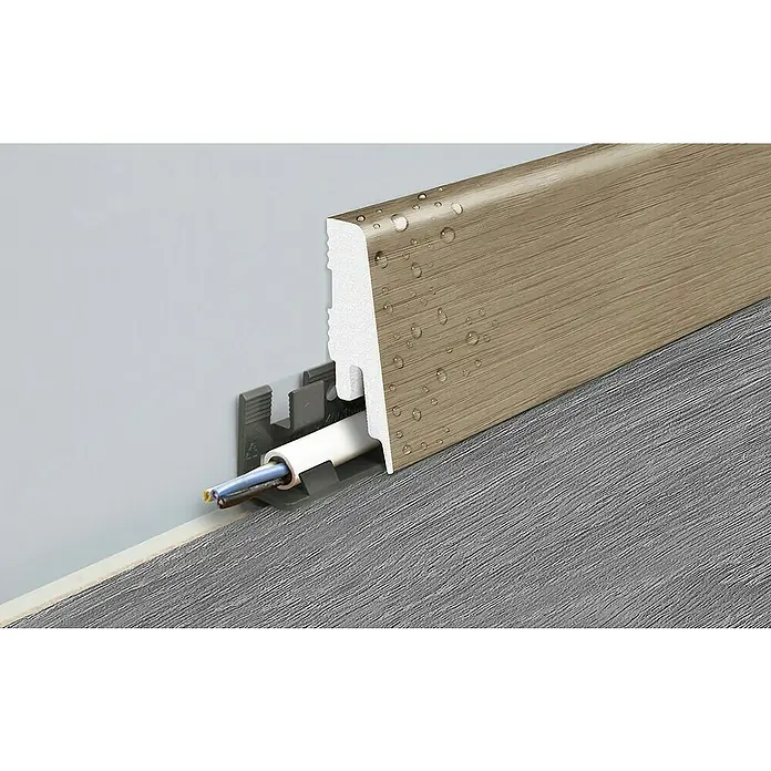 LOGOCLIC Sockelleiste Element Pro K58 C - 240 cm x 18 mm x 58 mm, Seaflower - Nahaufnahme einer Fußleiste in Holzoptik mit integriertem Kabelkanal und Wassertropfen für eine elegante und funktionale Raumgestaltung.
