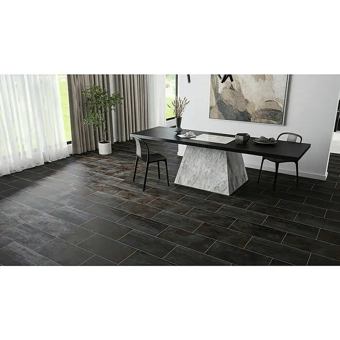 Feinsteinzeugfliese Flatiron - 30,8 x 61,5 cm, Schwarz, Matt - Dunkle Bodenfliesen im Langformat verlegt in einem Esszimmer mit modernem Tisch und Stühlen, schaffen ein elegantes und zeitgemäßes Ambiente.