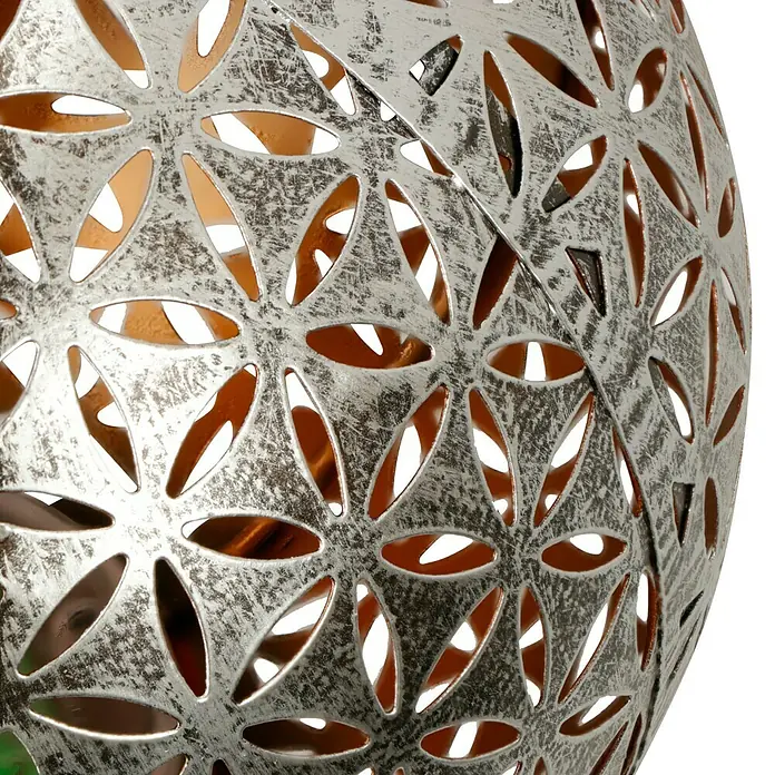 BAUHAUS Solar-Dekoleuchte Kugel - 0,06 W, Silber, IP44 - Nahaufnahme einer silberfarbenen Metallkugel mit filigranen, blütenförmigen Ausschnitten, die ein warmes Licht durchscheinen lassen. Dekorative Gartenleuchte für stimmungsvolle Abende.