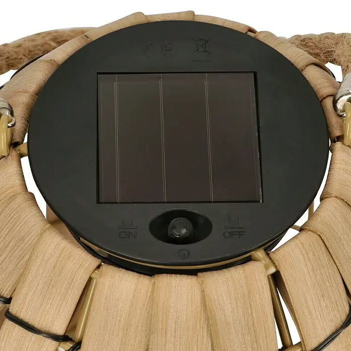 BAUHAUS Solar-Tischleuchte Natural - Rattan, IP44 - Nahaufnahme des Solarpanels einer Dekoleuchte mit Ein-/Ausschalter, umgeben von einem Weben.
