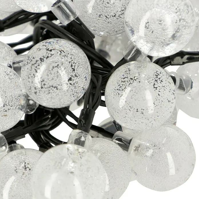 BAUHAUS LED-Solar-Lichterkette Balls - Außen, 6,9 m, Warmweiß - Nahaufnahme einer Lichterkette mit klaren Kugelbirnen, die ein dekoratives und stimmungsvolles Licht erzeugen.