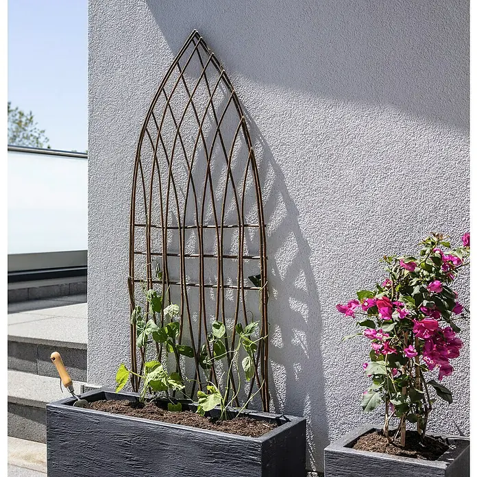 Windhager Rankgitter Weide Spitzbogen - B x H: 55 x 150 cm, Gebogen, Holz - Eine rustikale Rankhilfe aus Metall mit Pflanzen in einem Pflanzkasten. Ideal für Kletterpflanzen, um stilvoll im Garten oder auf der Terrasse zu wachsen.