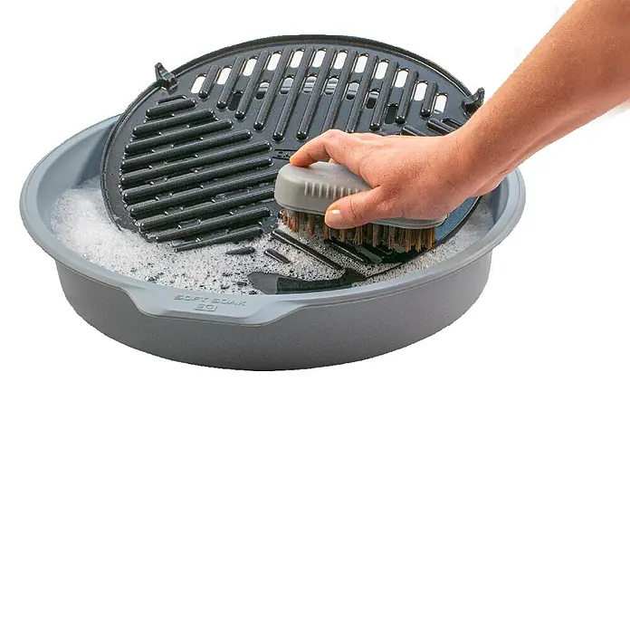 Cadac Spülwanne Soft Soak 40 - Durchmesser: 44,5 cm, Passend für: Grillroste bis Ø 40 cm - Bild einer Spülwanne mit Grillrost, die mit einer Bürste gereinigt wird. Ideal für die einfache Reinigung von Grillzubehör.