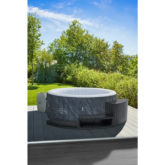 Malibu Whirlpool-Umrandung - B x T x H: 95 x 36,5 x 55 cm, Anthrazit - Ein aufblasbarer Lay-Z-Spa Whirlpool mit integrierter Pumpe und Treppe auf einer Terrasse mit Garten im Hintergrund.