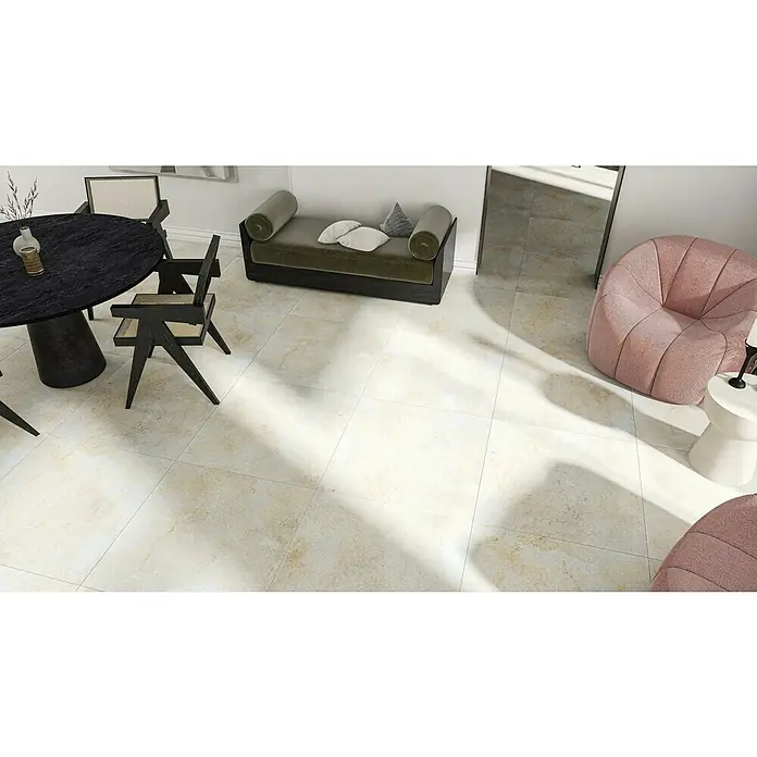 Marazzi Feinsteinzeugfliese Jerusalem Oase Avorio - 75 x 75 cm, Sandstein-Beige, Matt - Innenaufnahme eines Raumes mit einem Esstisch, Stühlen, einer Bank und zwei rosa Sesseln, alles auf einem hellen Fliesenboden.
