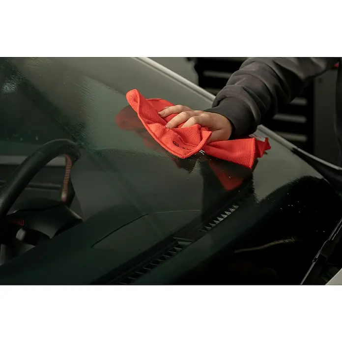 Nigrin Performance Scheibenreiniger - 500 ml - Ein rotes Mikrofasertuch wird verwendet, um die Windschutzscheibe eines Autos zu reinigen und eine klare Sicht zu gewährleisten.