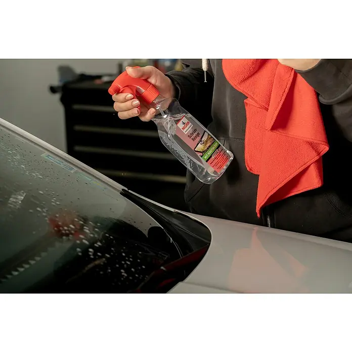 Nigrin Performance Scheibenreiniger - 500 ml - Reinigung eines Autos mit Nigrin Scheibenreiniger und einem Tuch. Die klare Flasche mit rotem Sprühkopf ist gut sichtbar.
