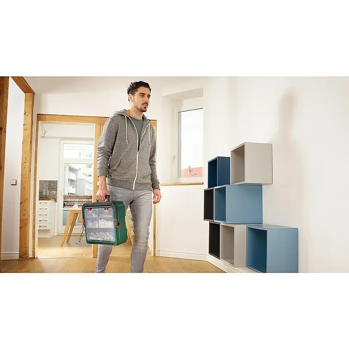Bosch Power for All 18V Akku-Schlagbohrschrauber UniversalImpact 18V - 18 V, 2 Akkus, 1,5 Ah, 34 Nm, 210 -tlg. - Mann mit Werkzeugkoffer. Der Werkzeugkoffer ist mit verschiedenen Werkzeugen gefüllt. Praktische Aufbewahrung für unterwegs.