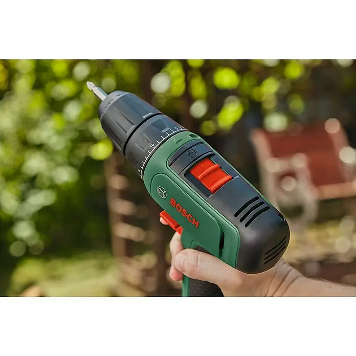 Bosch Power for All 12V Akku-Bohrschrauber EasyDrill 1200 - 12 V, 1 Akku, 1,5 Ah, 30 Nm - Nahaufnahme eines grünen und schwarzen Bosch-Akkuschraubers, der von einer Hand vor einem verschwommenen Hintergrund gehalten wird.