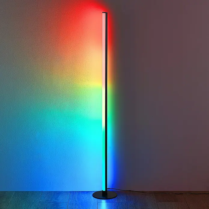 Trio Lighting Lámpara de pie LED Tendo - 11 W, Altura: 115 cm, Negro, RGBW - Esta toma muestra una moderna lámpara de pie de esquina RGB con degradado de color, creando un ambiente de luz.