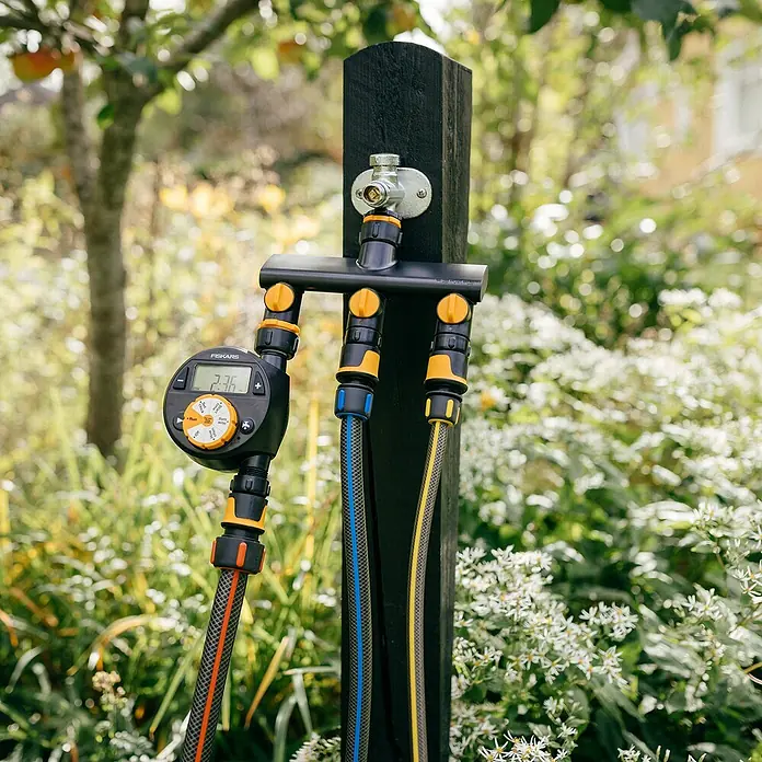 Fiskars 3-Wege-Umschaltventil - Ø 21 mm (G 1/2"), Ø 26,5 mm (G 3/4"), Ø 33,3 mm (G 1") - Die Fiskars Bewässerungsuhr mit drei Ausgängen, ist am Wasserhahn befestigt und mit Gartenschläuchen verbunden. Bewässerung leicht gemacht.