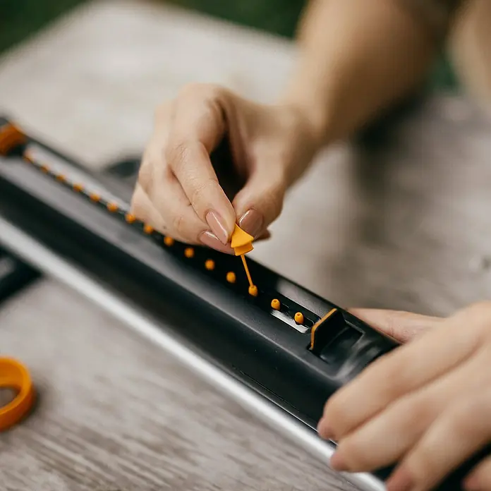 Fiskars Ersatzteil-Set Oszillierende Regner - Passend für: Fiskars X-Series™ Oszillierende Regnern S–L und S–M sowie Comfort Oszillierende Regnern S–L und S–M - Nahaufnahme einer Person, die einen Fiskars Quilling-Stift auf einem Holztisch benutzt.